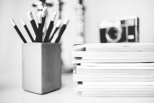 Schreibtisch mit Stiften und Noitzbüchern